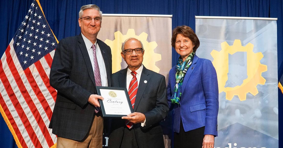 Eric Holcomb, Elaine Bedel standing next to a man in a suit and tie